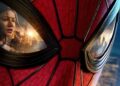 Close-up of Spider-Man mask with city skyline reflected in the left eye lens and a woman's face visible in the lens edge.